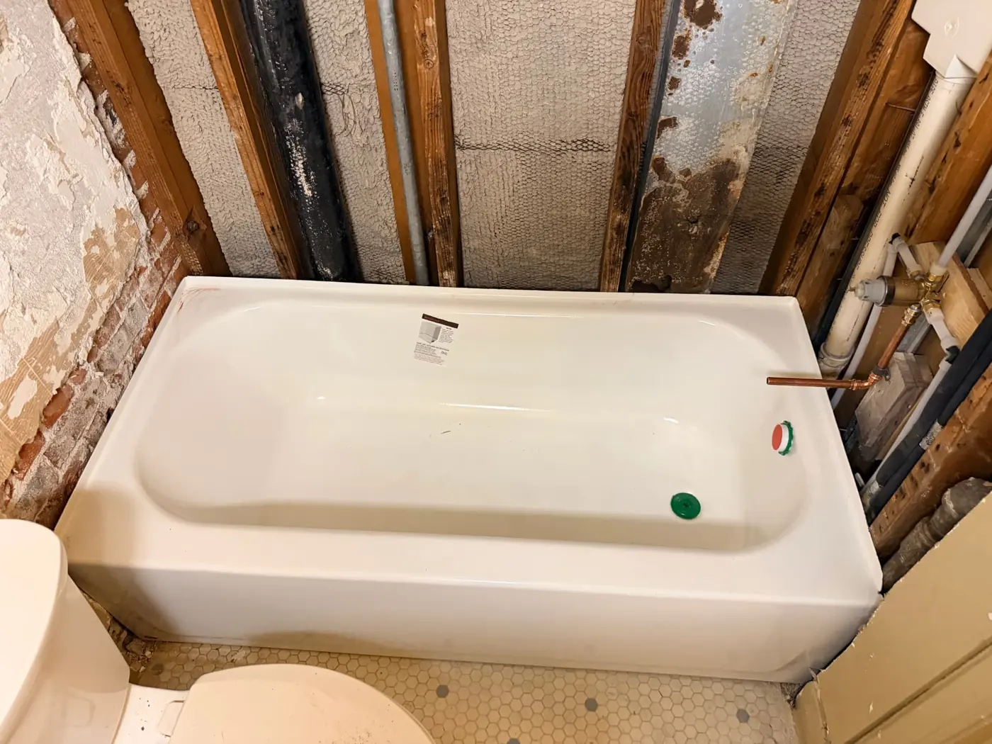 New white bathtub installed with new supply and drain plumbing after asbestos abatement and mold remediation